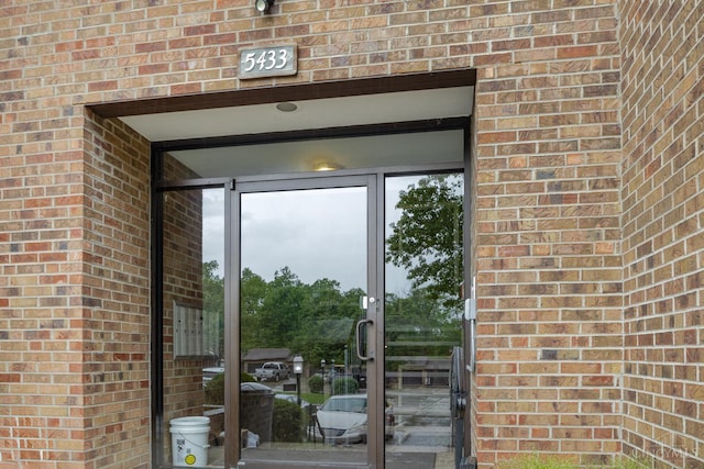 property entrance featuring brick siding