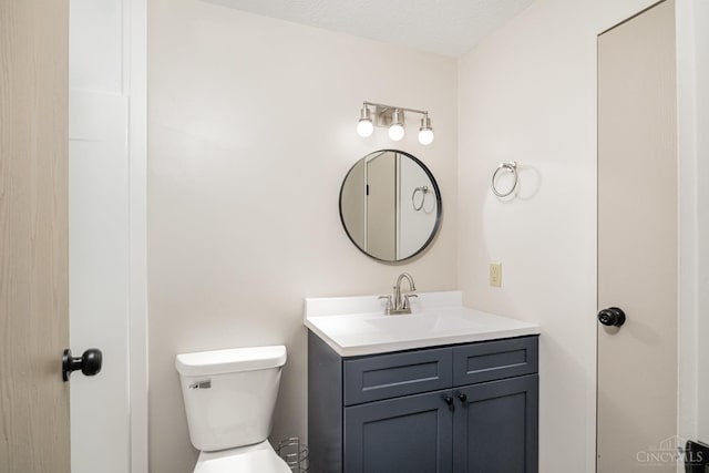 half bath featuring vanity and toilet