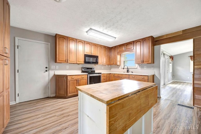 2774 N Law Rd, Reily Twp, OH 45056 - kitchen featuring black microwave, stainless steel range with electric stovetop, light wood-type flooring, a sink, and wooden counters