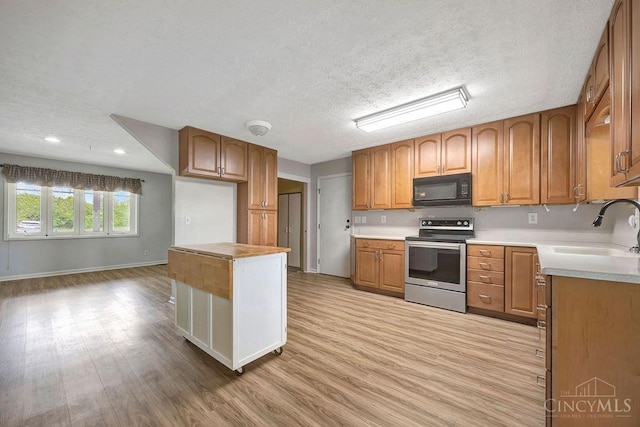 2774 N Law Rd, Reily Twp, OH 45056 - kitchen with black microwave, stainless steel range with electric stovetop, a sink, light wood finished floors, and a textured ceiling