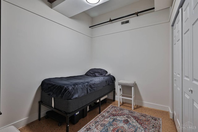 bedroom with baseboards and dark speckled floor