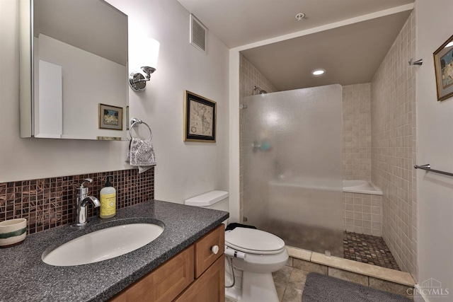 full bath featuring a tile shower, toilet, vanity, tasteful backsplash, and recessed lighting