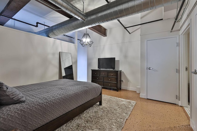 bedroom featuring speckle patterned floor, baseboards, and a chandelier