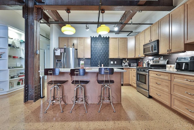kitchen featuring appliances with stainless steel finishes, a breakfast bar area, decorative backsplash, and light countertops
