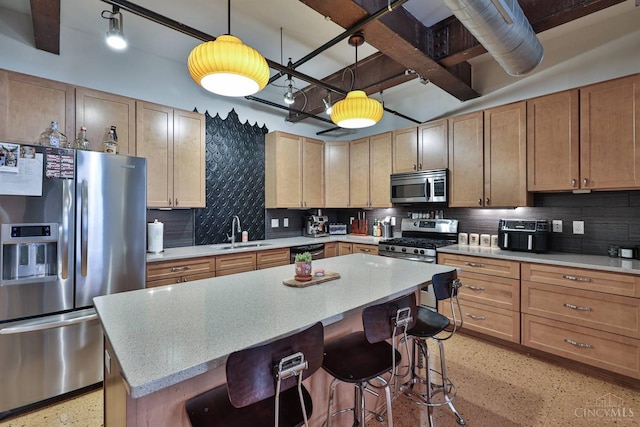 kitchen featuring stainless steel appliances, a sink, dark aggregate flooring, and a kitchen breakfast bar