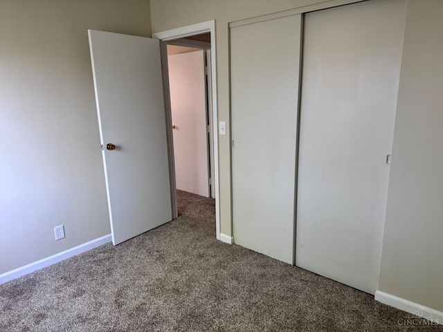 unfurnished bedroom with carpet floors, a closet, and baseboards