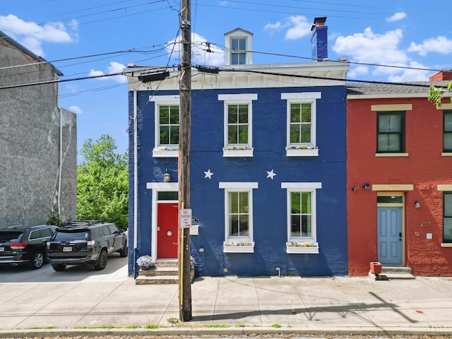 multi unit property with entry steps, brick siding, and a chimney