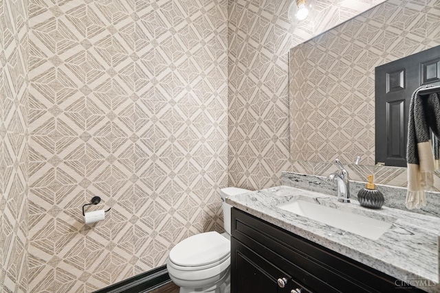 half bathroom featuring toilet and vanity