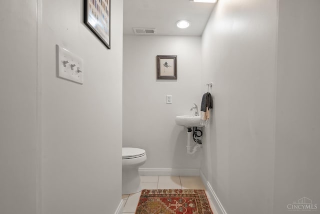 bathroom with tile patterned floors, toilet, and baseboards