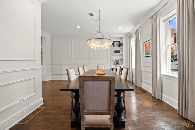 dining area featuring a decorative wall, a chandelier, dark wood finished floors, recessed lighting, and ornamental molding