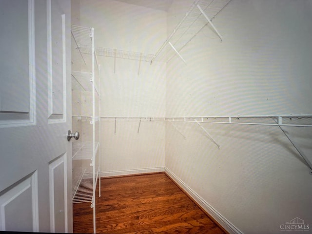 walk in closet with wood finished floors