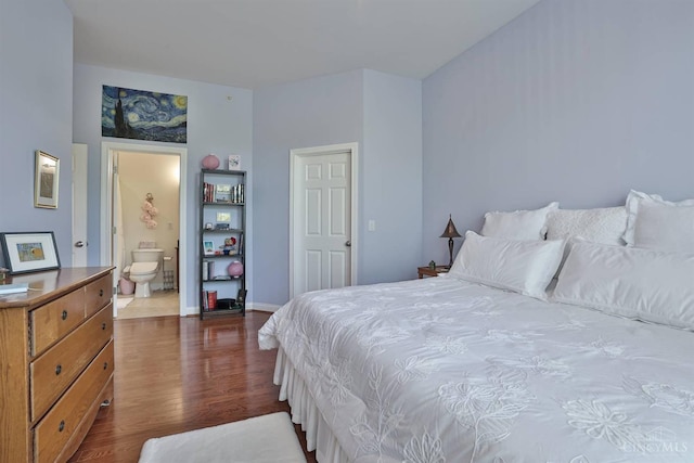bedroom featuring dark wood finished floors, ensuite bathroom, and baseboards