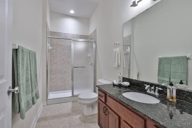 bathroom featuring a stall shower, toilet, vanity, and tile patterned flooring
