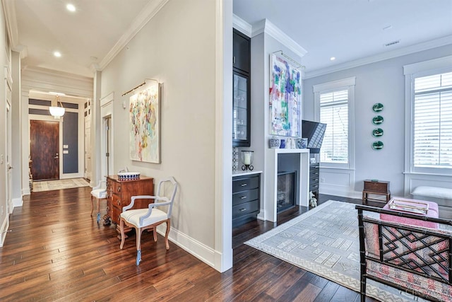 living room featuring wood-type flooring, ornamental molding, recessed lighting, baseboards, and a fireplace