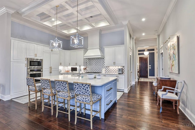 kitchen featuring stainless steel appliances, premium range hood, white cabinets, crown molding, and light countertops