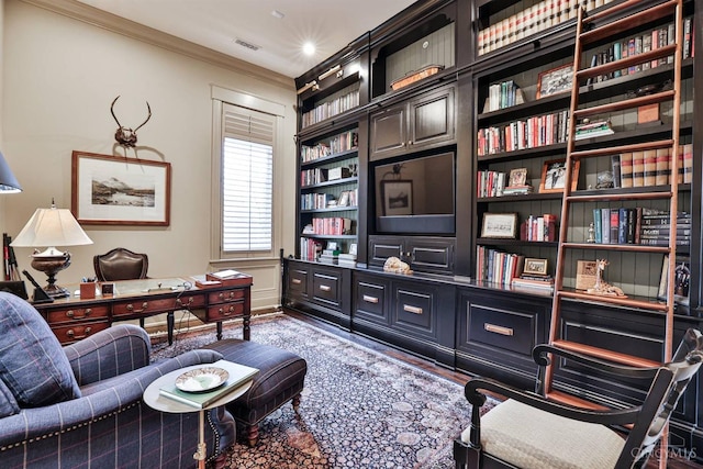 office with ornamental molding, built in shelves, and wood finished floors