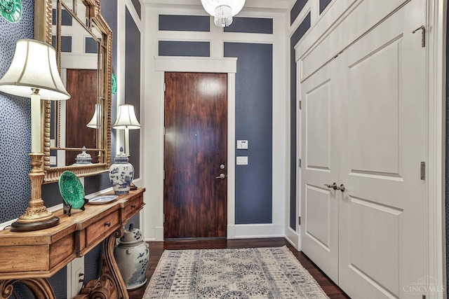 entryway with dark wood-style flooring and baseboards