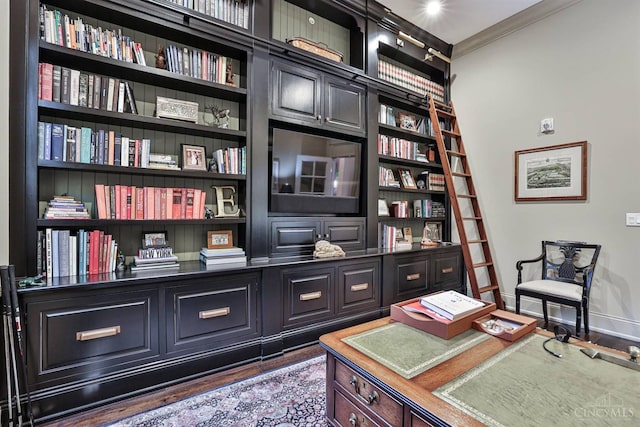 office area featuring baseboards, ornamental molding, wood finished floors, and built in shelves