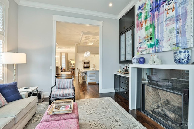 indoor dry bar with dark wood-type flooring, ornamental molding, stainless steel appliances, baseboards, and recessed lighting