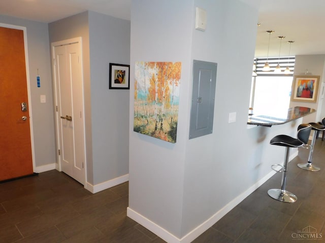 hallway with electric panel and baseboards