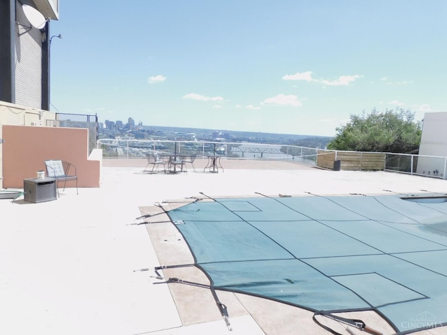 view of swimming pool featuring central AC and fence