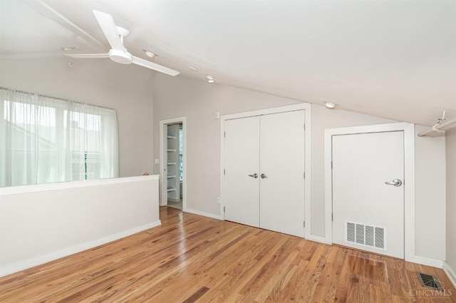 unfurnished bedroom with vaulted ceiling, wood finished floors, a ceiling fan, a closet, and baseboards