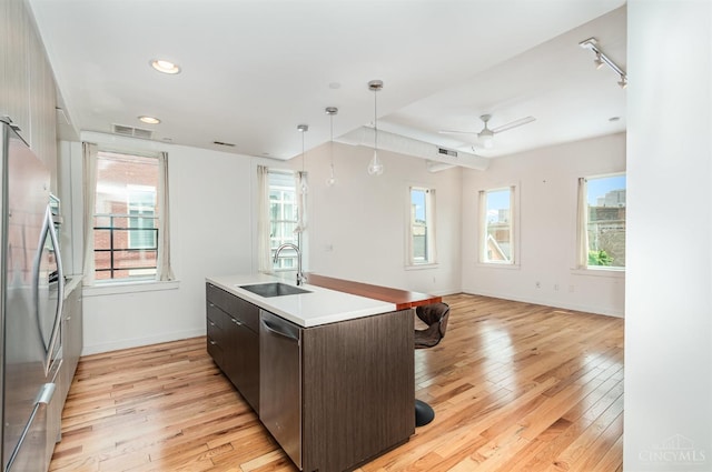 kitchen featuring a sink, appliances with stainless steel finishes, light wood-style floors, healthy amount of natural light, and recessed lighting