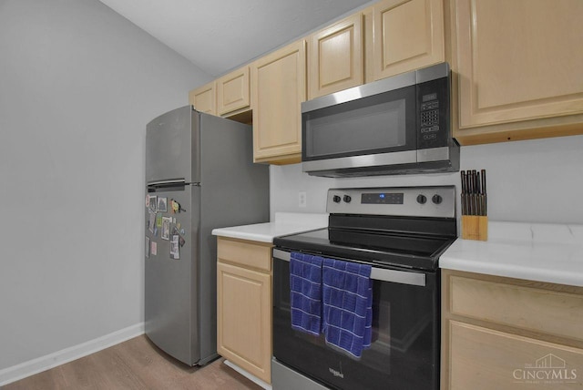1740 Piper Ln Unit 206, Centerville, OH 45440 - kitchen with stainless steel appliances, light brown cabinets, light wood-style flooring, light countertops, and baseboards