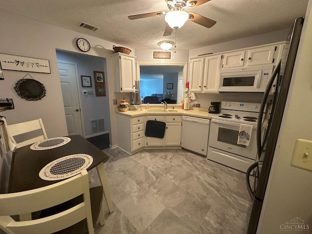 kitchen with white appliances, a sink, white cabinetry, a ceiling fan, and light countertops