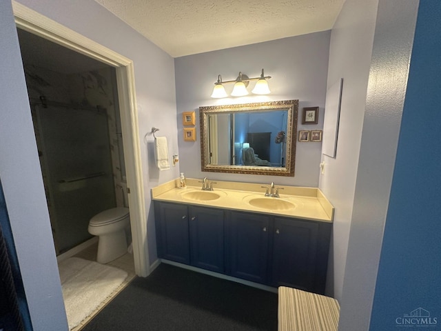 bathroom featuring double vanity, a textured ceiling, a shower, and toilet