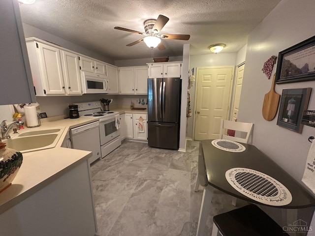 kitchen with white appliances, a sink, a textured ceiling, a ceiling fan, and white cabinetry