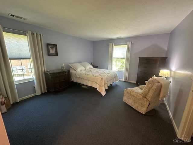 bedroom with dark carpet and baseboards
