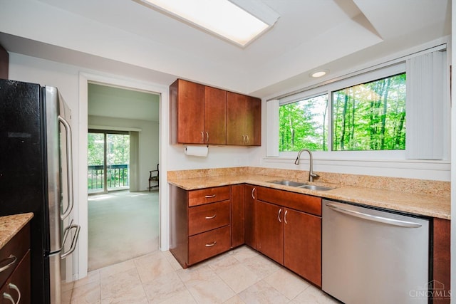 5672 Crooked Tree Ln, Miami Twp, OH 45150 - kitchen with appliances with stainless steel finishes, a sink, light stone countertops, light tile patterned floors, and brown cabinetry