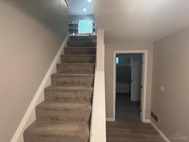 staircase with wood finished floors and baseboards