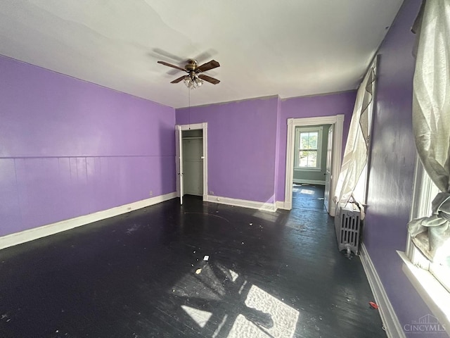 spare room featuring ceiling fan, baseboards, and heating unit