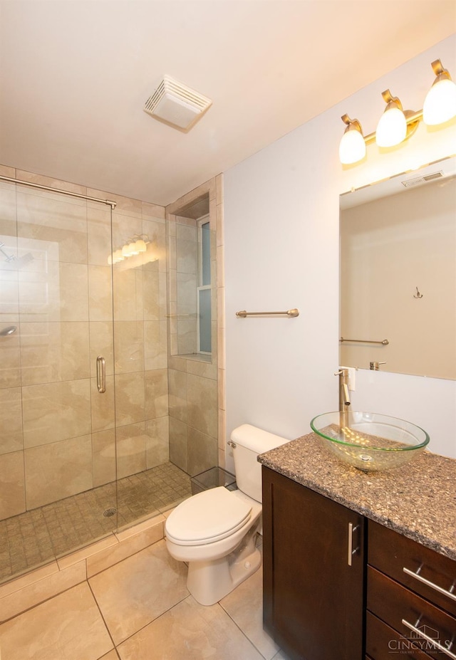 bathroom with tile patterned flooring, toilet, vanity, and a shower stall