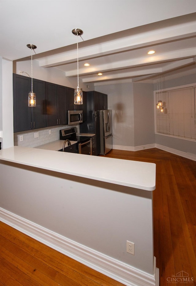 kitchen featuring stainless steel appliances, beam ceiling, light countertops, hanging light fixtures, and recessed lighting