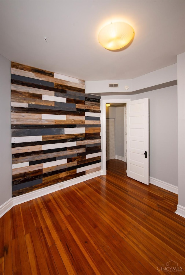 unfurnished room featuring wood finished floors and baseboards