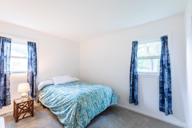 bedroom featuring light carpet and baseboards