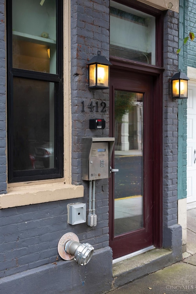 view of exterior entry featuring brick siding