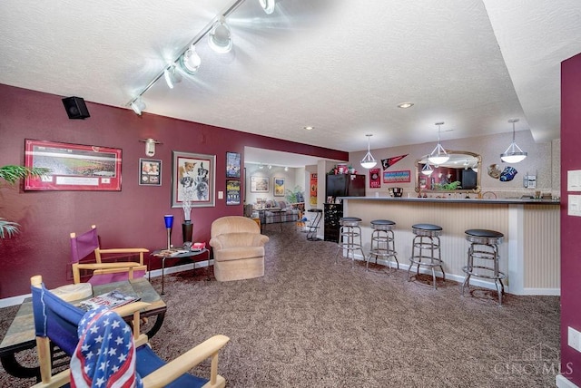 1668 Nichole Ct, Hamilton, OH 45013 - carpeted living area featuring a textured ceiling, baseboards, and rail lighting