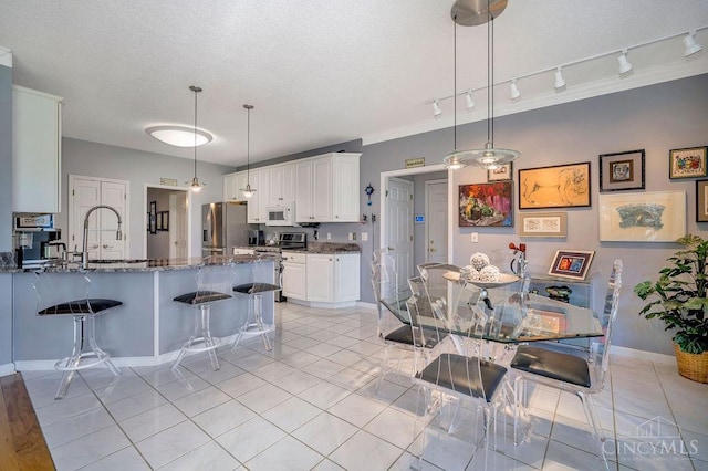 1668 Nichole Ct, Hamilton, OH 45013 - dining area with rail lighting, light tile patterned floors, and baseboards