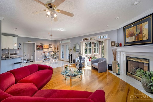 1668 Nichole Ct, Hamilton, OH 45013 - living room with a textured ceiling, ornamental molding, a ceiling fan, a fireplace with flush hearth, and wood finished floors