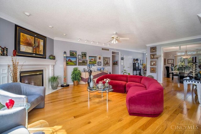 1668 Nichole Ct, Hamilton, OH 45013 - living area with ornamental molding, a textured ceiling, a ceiling fan, wood finished floors, and a high end fireplace