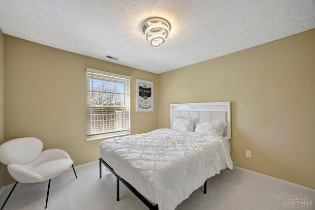 bedroom with carpet floors, baseboards, and a textured ceiling