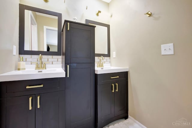 bathroom with decorative backsplash, two vanities, and baseboards