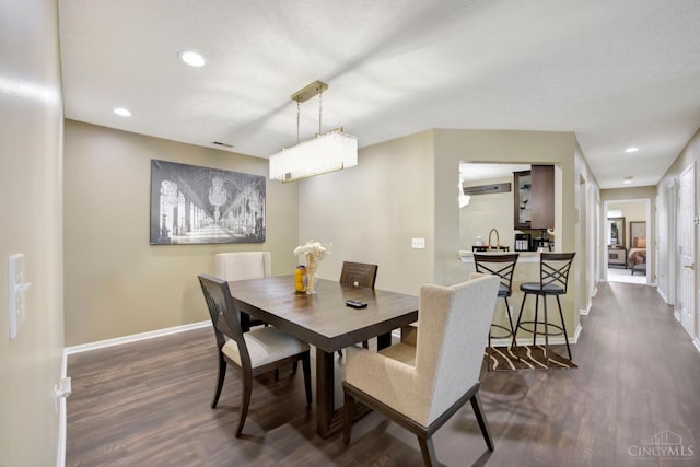 dining room featuring dark wood-style flooring, baseboards, and recessed lighting