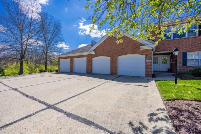 view of front of home featuring brick siding and concrete driveway