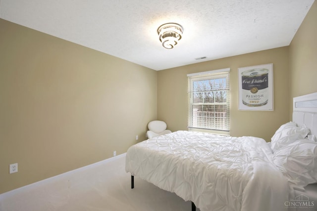 carpeted bedroom with baseboards and a textured ceiling
