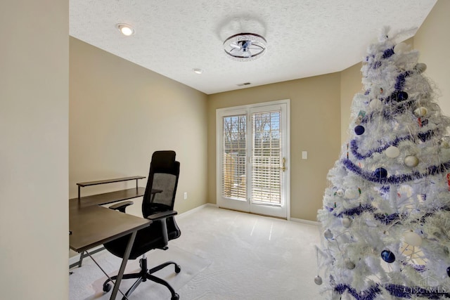 carpeted office with baseboards and a textured ceiling